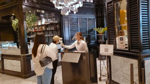 Employee at Restaurant Measuring Temperature of Customers With Thermometer Stock Footage 130601319