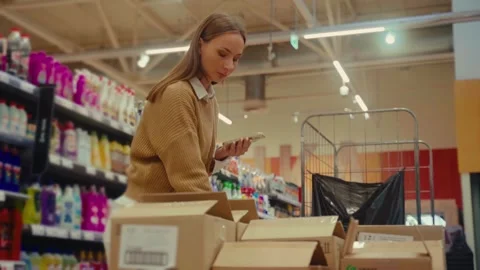 Employee restocking supplies while checking inventory in a retail store Stock Footage 293673842