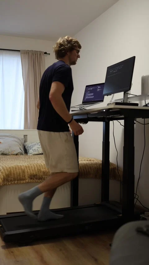 Employee running on treadmill while working at home Stock Footage 346881440