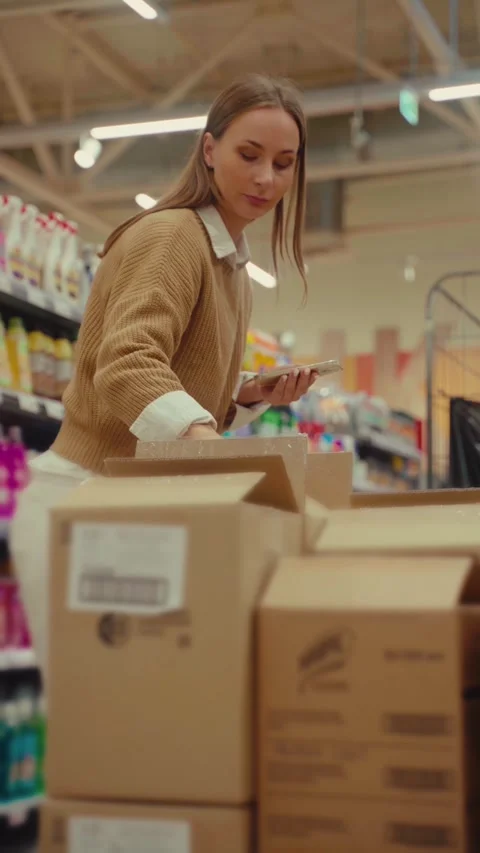 Employee scans products while organizing inventory in a retail store Stock Footage 293675271