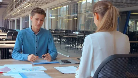 Employee sitting at the desk talking with client Stock Footage 103106533