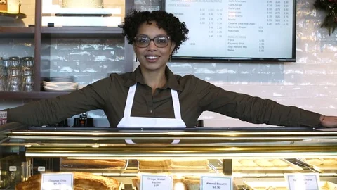 Employee standing behind a display case in a bakery 動画素材 77080085