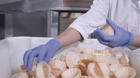 Employee takes waffle baskets preparing for packaging Stock Footage 124299427