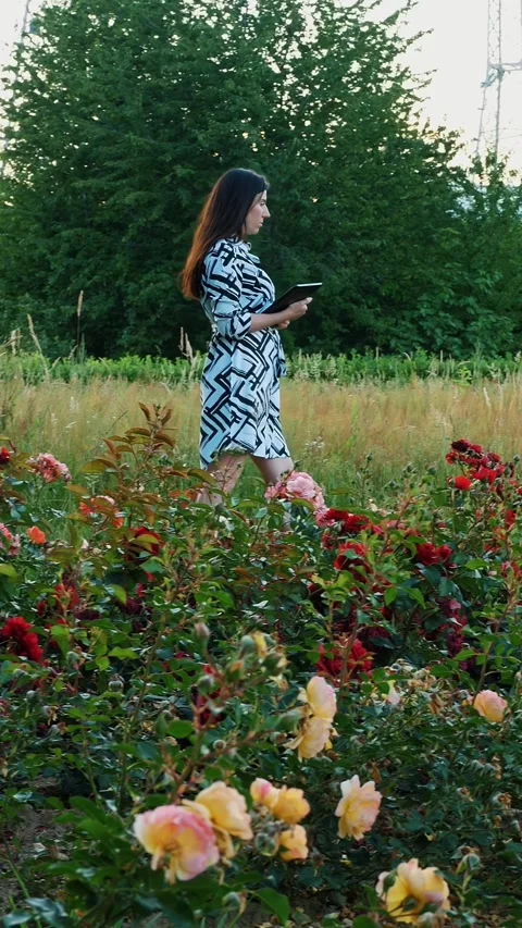 Employee taking notes on work. Flowers. Electrical substation. Horticultural Stock Footage 314228646
