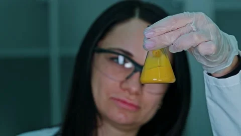 An employee of a technical laboratory holds a test tube with paint in her Stock Footage 239859510