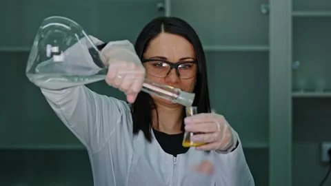 An employee of a technical laboratory holds a test tube with paint in her Stock Footage 239859538