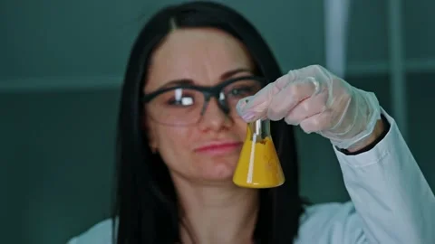 An employee of a technical laboratory holds a test tube with paint in her Stock Footage 239859549