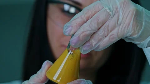 An employee of a technical laboratory holds a test tube with paint in her Stock Footage 239859630