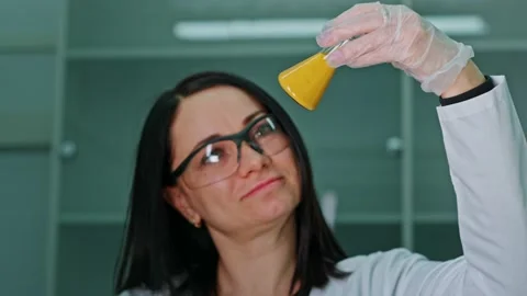 An employee of a technical laboratory holds a test tube with paint in her Stock Footage 239859642