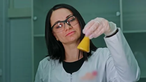 An employee of a technical laboratory holds a test tube with paint in her Stock Footage 239859694