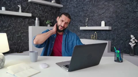 An employee types at home on a computer very hot shakes his shirt Stock Footage 236588111