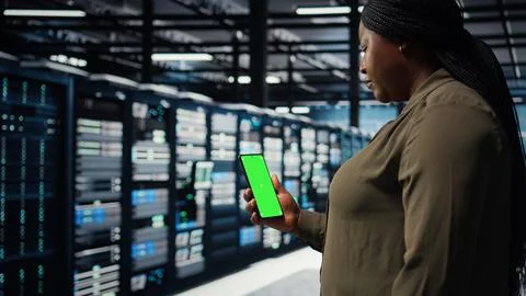Employee using app on mockup phone to check server hub energy consumption Stock Photos