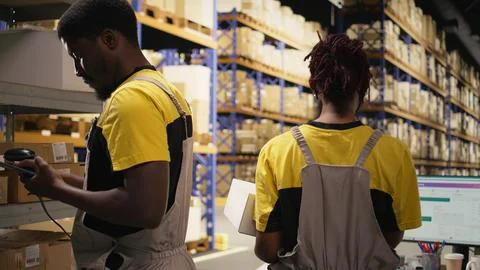 Employee using barcode scanner on cardboard boxes in fulfillment center Fotos Stock