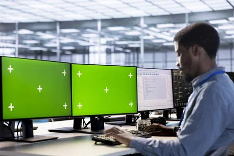 Employee using green screen PC in server hub to shield data Foto stock