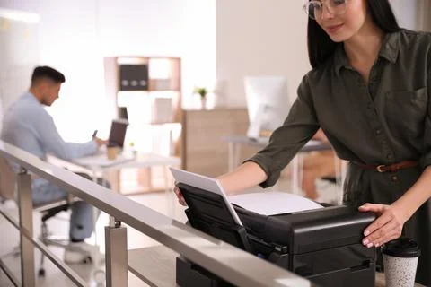 Employee using new modern printer in office Stock Photos