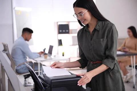Employee using new modern printer in office Stock Photos