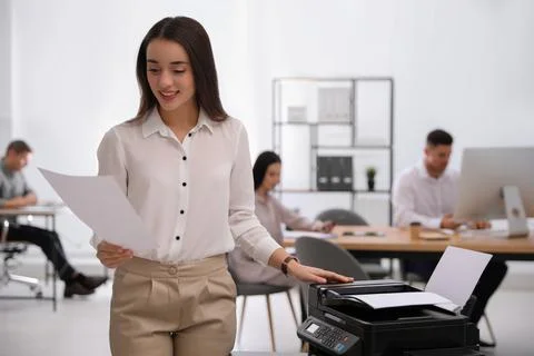 Employee using new modern printer in office Stock Photos