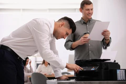 Employee using new modern printer in office Stock Photos