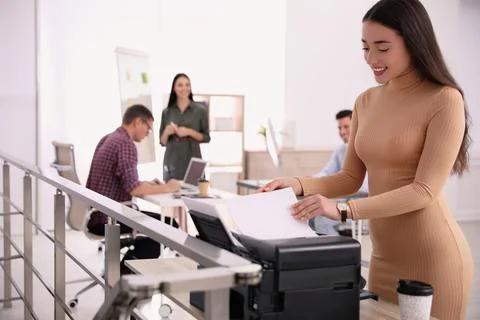 Employee using new modern printer in office Stock Photos