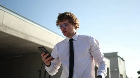 Employee walking to work constantly checking social media on smartphone Stock Footage 346362841