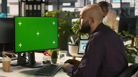 Employee at work using isolated screen PC, reading paperwork Foto stock