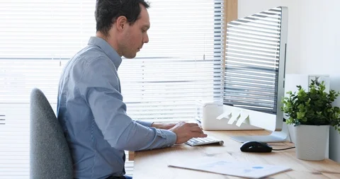 Employee working on computer in bright office workplace, typing on keyboard Stock Footage 122198441