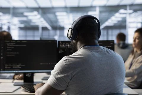 Employee working in computer network security data center listening music Stock Photos