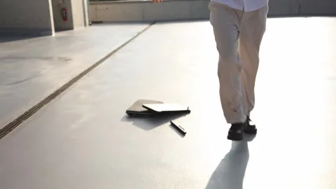 Employee working on laptop while walking smashes computer on ground after work f Video stock 346362715