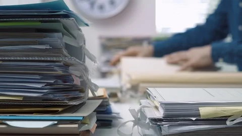 Employee working in the office and piles of paperwork Stock Footage