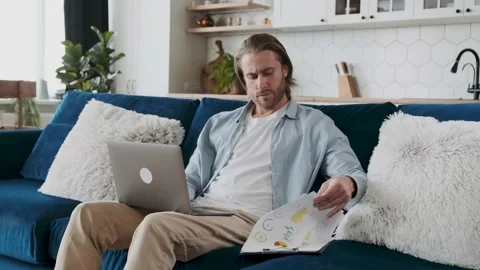 An employee working remotely on a report, looking at some statistical data and Stock Footage 195940448