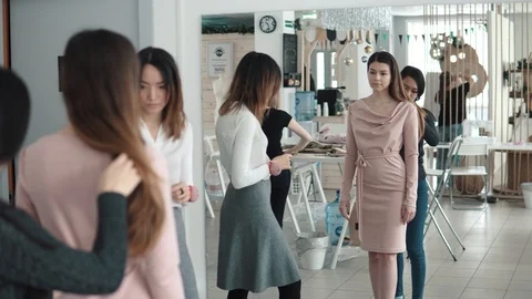 Employees atelie trying on clothes on the client. a group of fashion designers Stock Footage 89694724