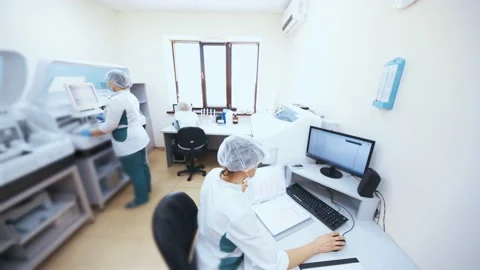 Employees of the biochemical laboratory work at a computer and examine samples Stock-Footage 190082348