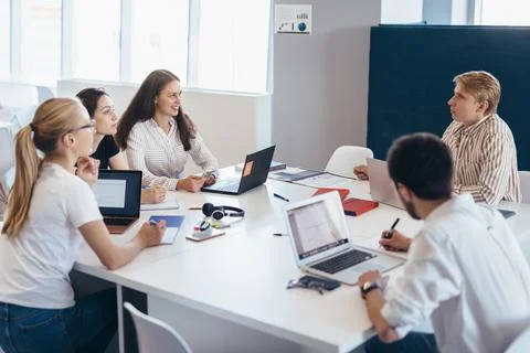 Employees communicate at work by sitting at table 写真素材
