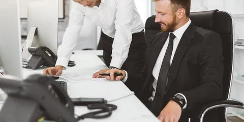 Employees of the company interact in the process of work and help each other in Foto stock