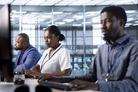 Employees in data center deploying and error checking utilities on computer Foto stock