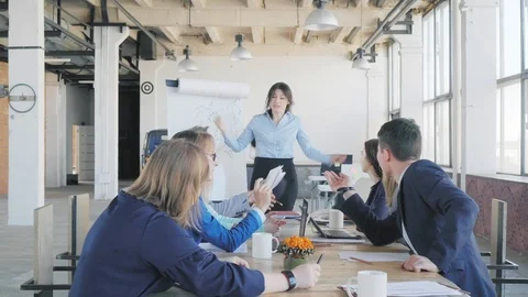 Employees discuss the presentation, sitting at the table. A female team leader Stock Footage 111589262