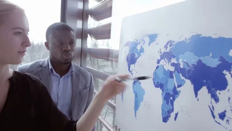 Employees discussing about the map estimating the global economy Stock Footage 73869298