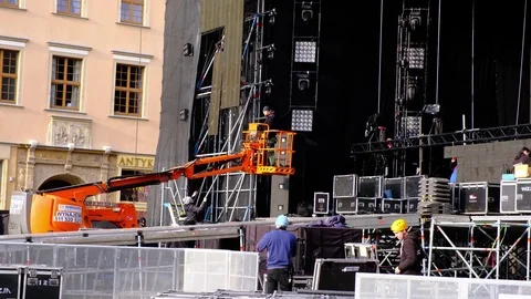 Employees dismantle the stage with a powerful industrial crane after a concert Stock Footage 124088745