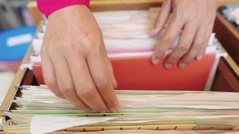 The employee's hand was searching for documents in the filing cabinet. Stock Footage 148101434
