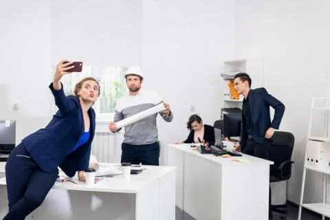Employees having fun in the office, posing, making funny faces a Stock Photos