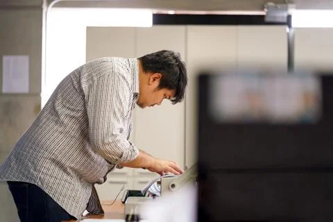 Employees man are preparing documents in the office. With Binding Machine Stock Photos