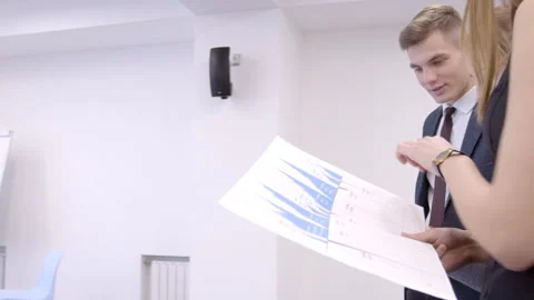 Employees of office study schedule of sales and pleased with result of leader. Stock-Footage 85645772