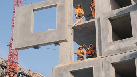 Employees pull rope installing concrete wall panels on floor Stock Footage 125930402