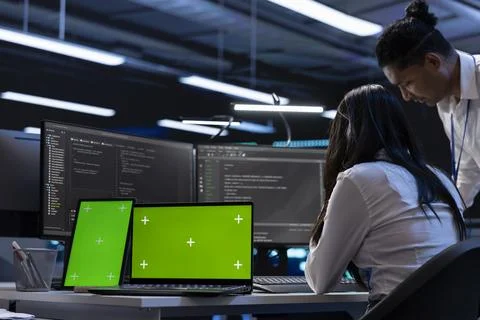Employees in server room checking systems bottlenecks using chroma key devices Stock Photos