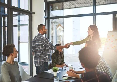 Employees, shaking hands and presentation in office with client, negotiation and Stock Photos