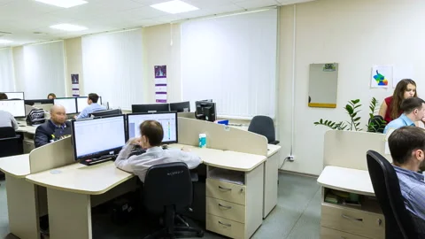 Employees Sit at Desks Work on Computers in Office Vídeo Stock 89914150