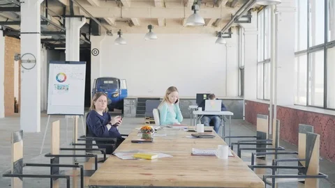 Employees sit at a large table after the meeting, talk on the phone and spin in Stock Footage 109561282