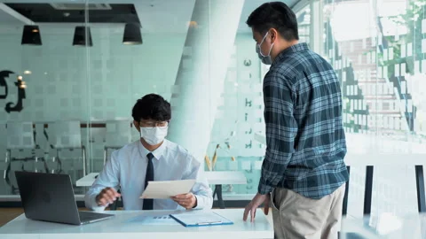 Employees submit documents at their office while wearing masks during the out 스톡 동영상 155323721