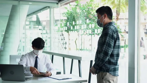Employees submit documents at their office while wearing masks during the out 스톡 동영상 155332517