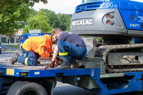 Employees of the technical relief organization attach an excavator to a low-l Stock Photos